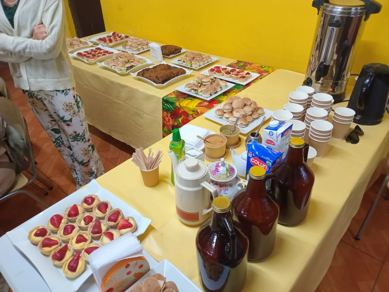 Mesa Nathivo con bocados dulces, sándwiches y bebidas calientes